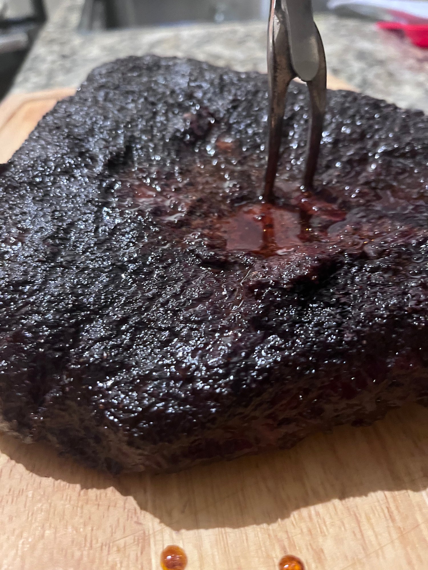 Tri-tip roast with bourbon coffee rub on a wooden cutting board 