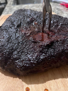 Tri-tip roast with bourbon coffee rub on a wooden cutting board 